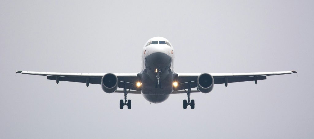 A commercial airliner captured head-on, preparing to land against a cloudy sky.- peramount