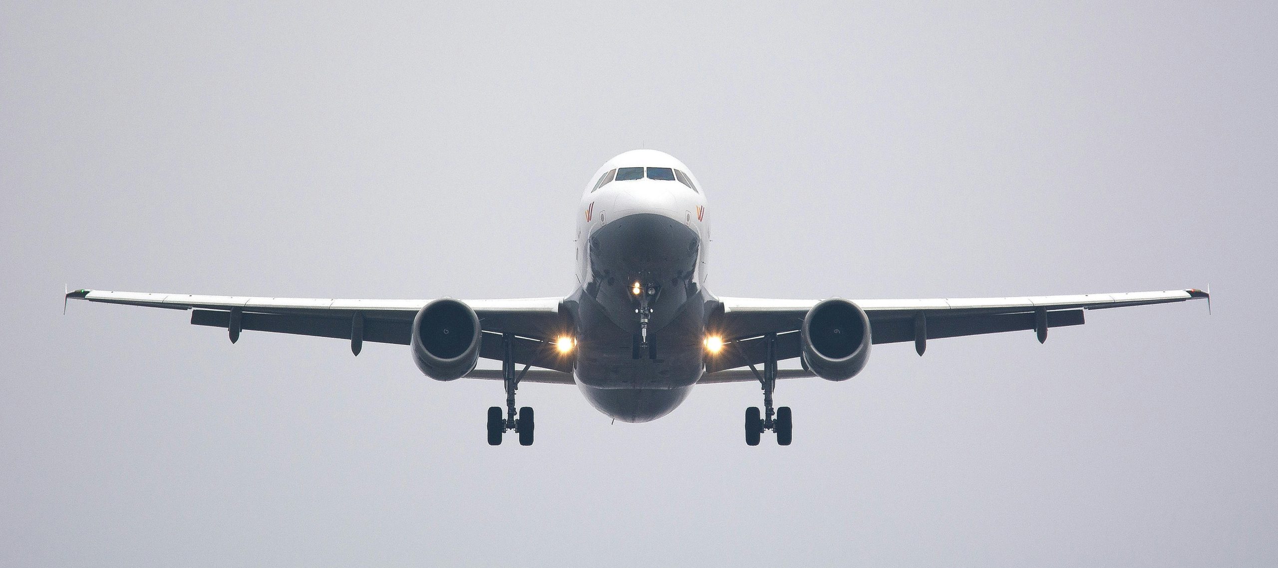 A commercial airliner captured head-on, preparing to land against a cloudy sky.- peramount